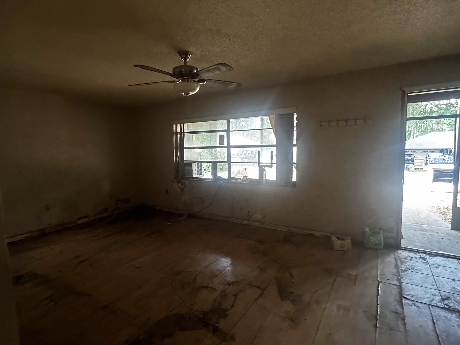 Leesburg kitchen and living area before renovation, stripped to bare floor