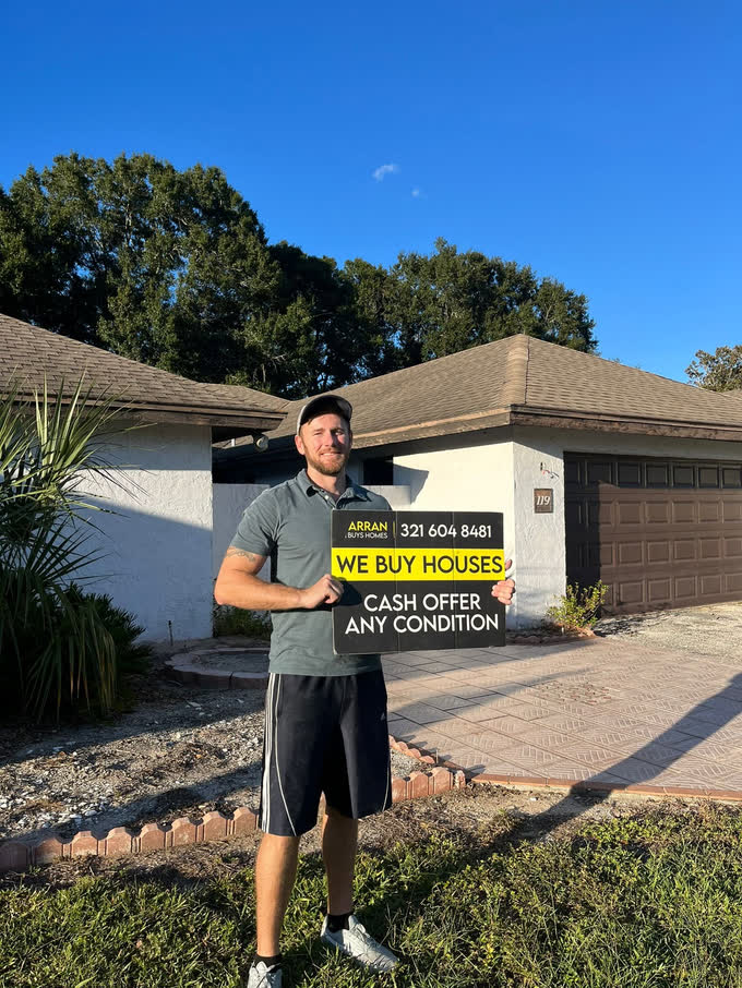 Arran with a we buy houses sign outside a home in Central Florida